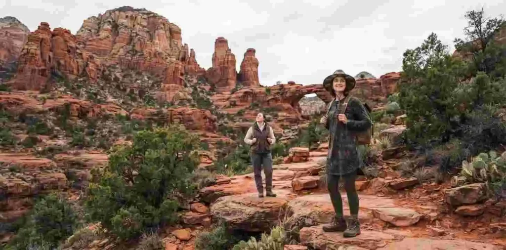 Travelers exploring dramatic red rock formations